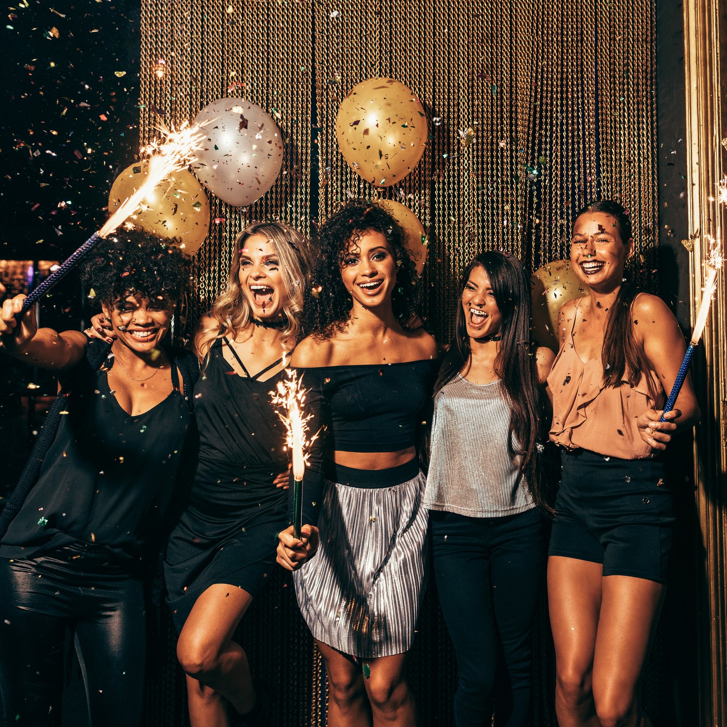 Group of friends celebrating with sparklers and confetti