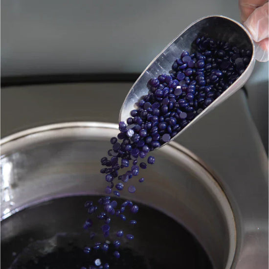Purple wax being poured into a wax bowl