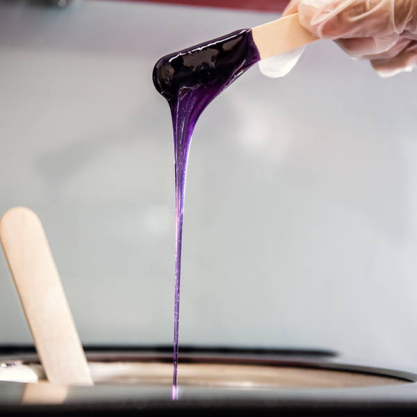 wax stick with purple wax dripping from it