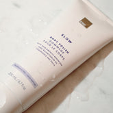 Tube of Fragrance Free Body Polish over a marble surface