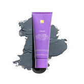 A tube of Face & Body Detoxifying Mask resting on top of a smudge of charcoal mask.