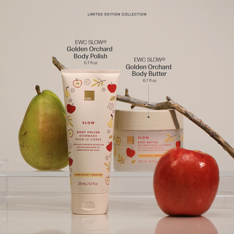 A skincare duo from EWC Fragrance featuring a tube of Golden Orchard Body Polish and Body Butter set against a cream background with fresh fruit props.