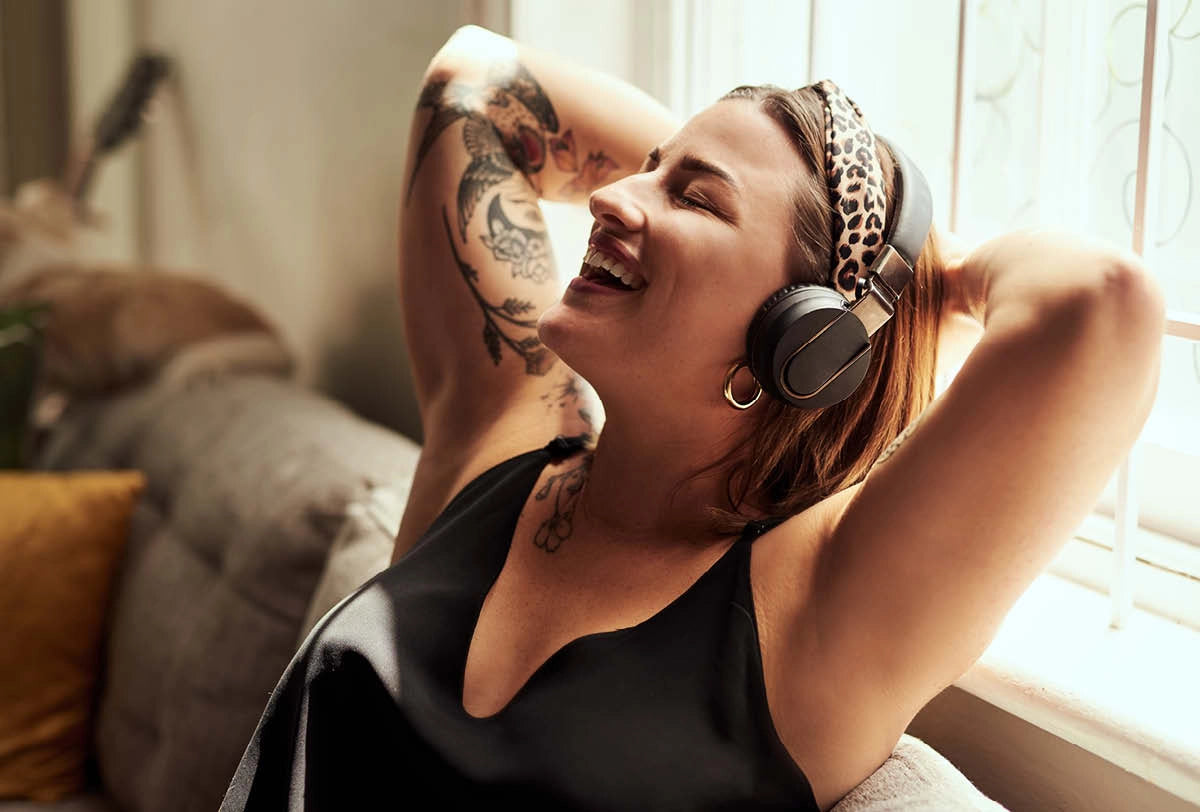 Woman wearing headphones in a cozy room with soft lighting