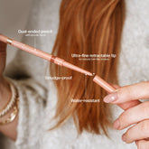 A close-up of a person holding a dual-ended eyebrow pencil, with text callouts describing features like the spoolie brush, retractable tip, smudge-proof formula, and water-resistant finish.