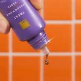 A drop of product drips off an open bottle of Ingrown Hair Bronzing Drops.