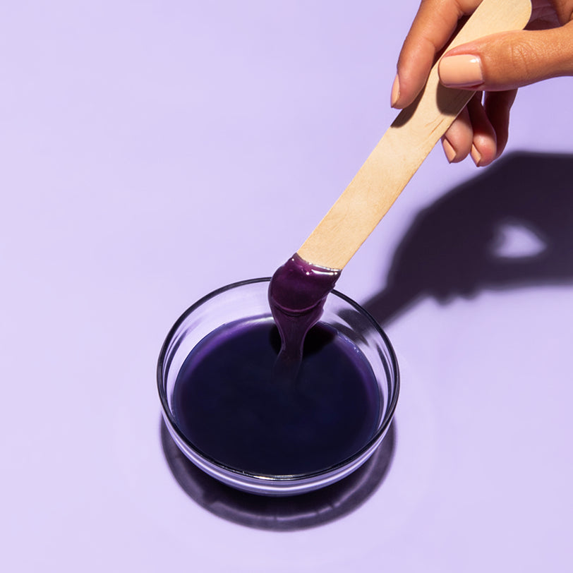 Hand holding a wax applicator with EWC's comfort wax