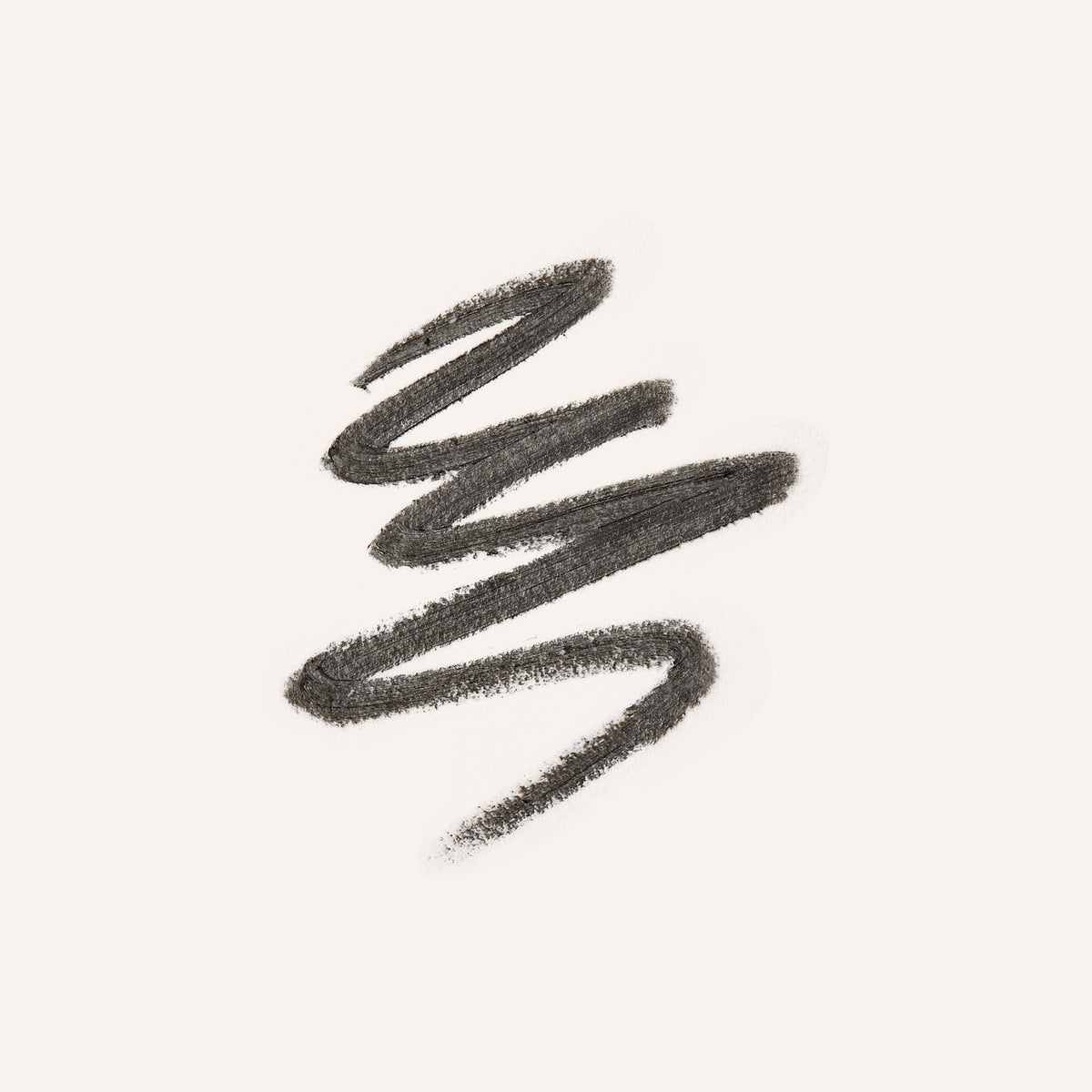 A textured swipe of dark brown eyebrow pencil on a solid off-white background.