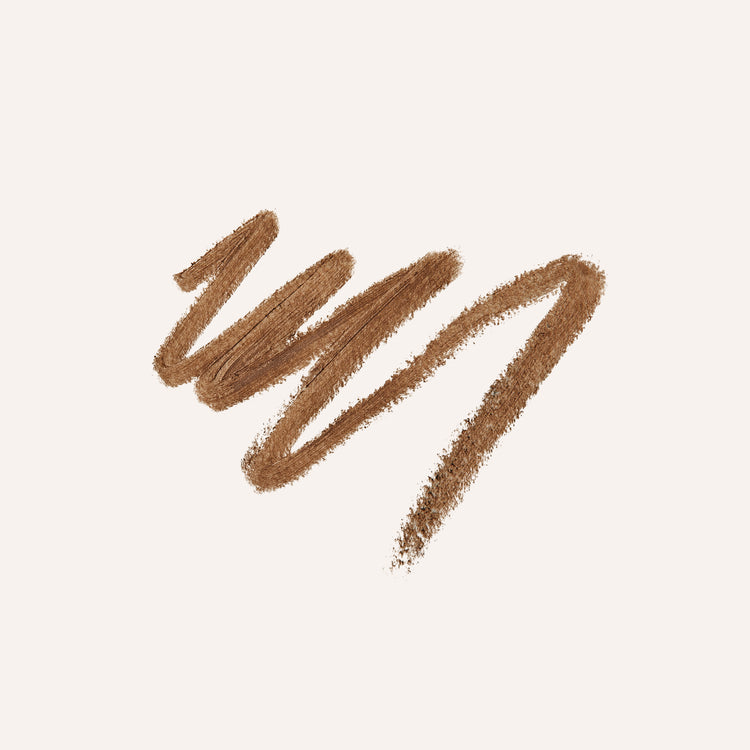 A textured swipe of medium brown eyebrow pencil on a solid off-white background.